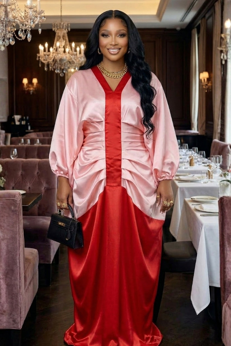 Woman in a bold contrast bubu dress featuring pink and red color blocking, elegantly styled in a restaurant setting.